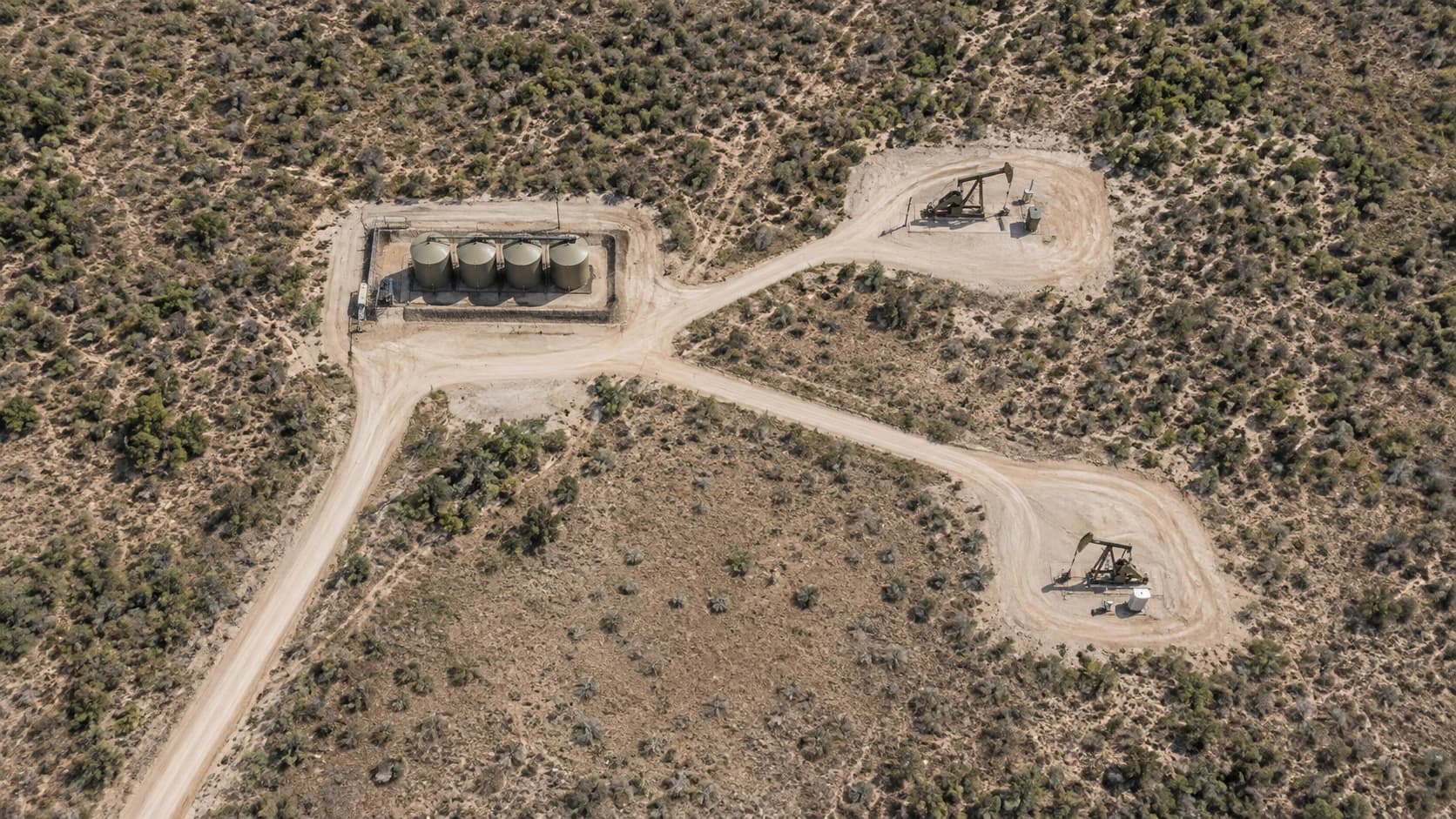 Illustrative aerial overview of a Texas oil lease with a tank battery, two rod pump wells, access roads and open fields.